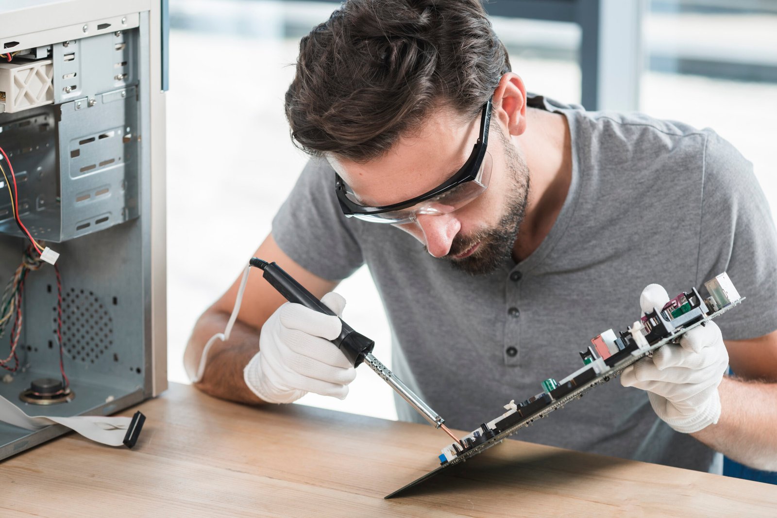 young man soldering computer circuit wooden desk scaled